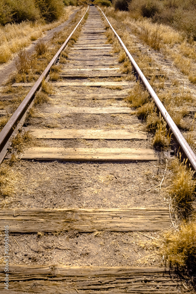 Train tracks in the desert with dry vegetaion Train tracks in the desert with dry vegetaion