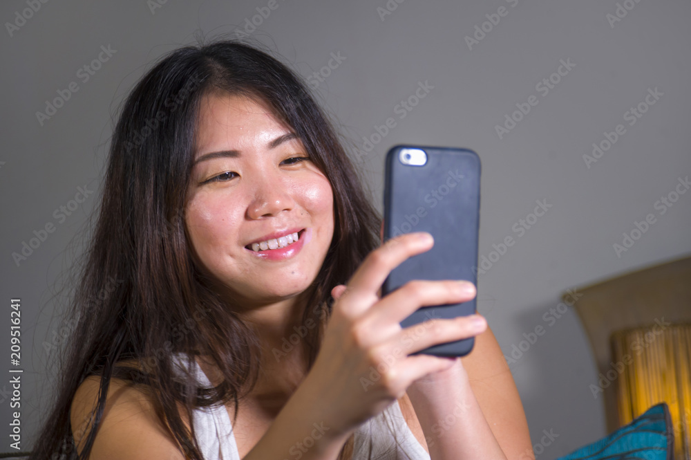 young sweet happy and pretty Asian Korean woman taking selfie picture with mobile phone for internet social media on mobile phone laughing at home young sweet happy and pretty Asian Korean woman taking selfie picture with mobile phone for internet social media on mobile phone laughing at home