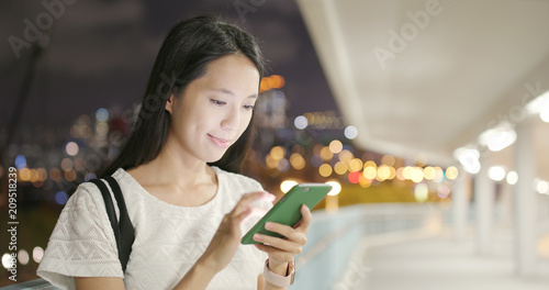 Photography Woman surfing online on cellphone at night