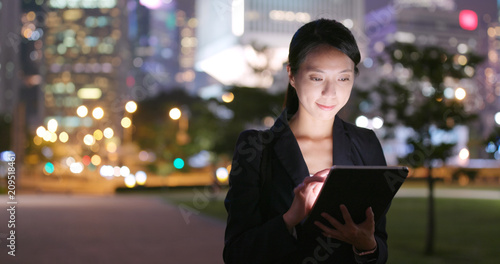 Wall Mural Businesswoman use of tablet computer at night