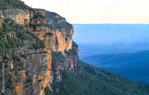 Large rocky cliffs and characteristic blue haze in the Blue Mountains National Park, Australia.