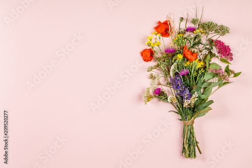 Wild flower bouquet on pastel color background photo