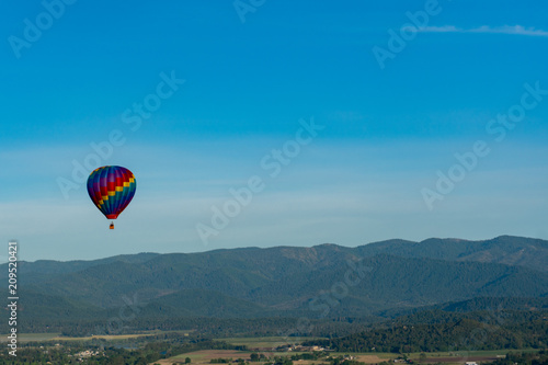 Hot air balloon over wooded hills