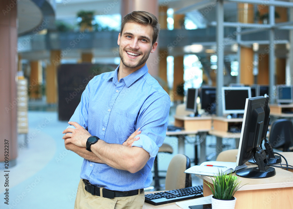 Young man posing confident and positive in professional workplace office with space. - obrazy, fototapety, plakaty 