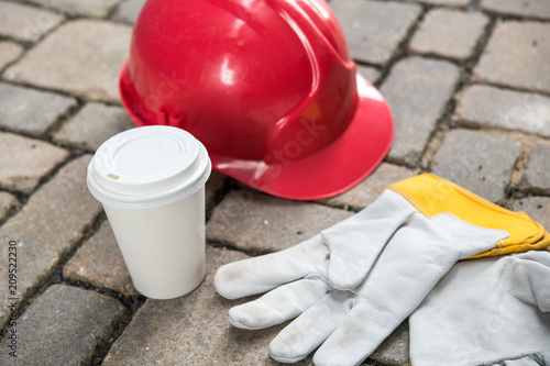 red helmet, coffee mug and work gloves