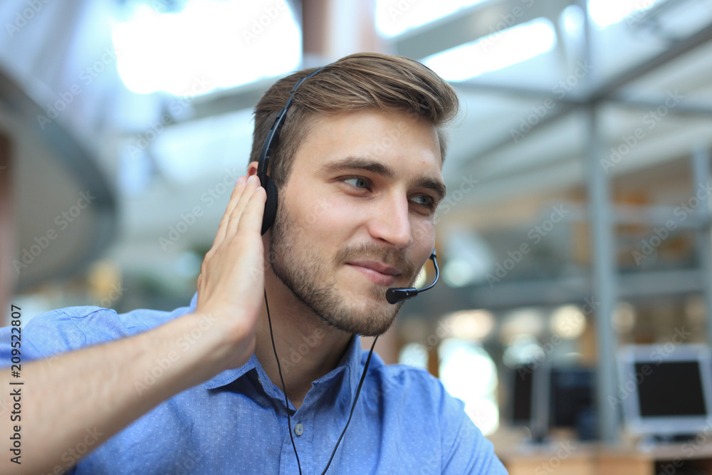 Smiling friendly handsome young male call centre operator. Smiling friendly handsome young male call centre operator.