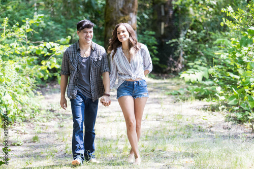 Happy young hispanic couple hiking on a trail