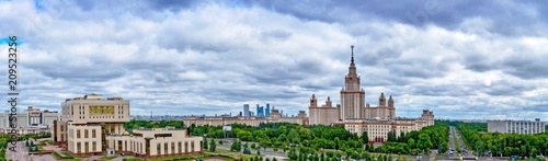 Wide angle long panoramic view of Moscow university campus under dramatic sky with stormy clouds in spring