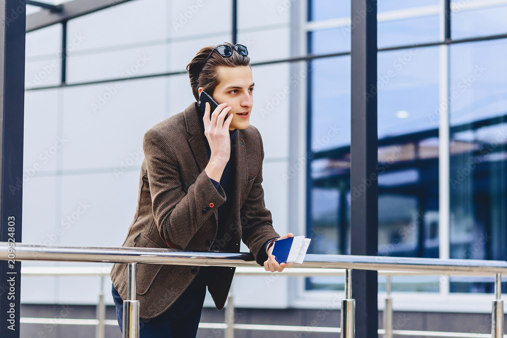 stylish attractive guy in jacket with phone passport and tickets stylish attractive guy in jacket with phone passport and tickets