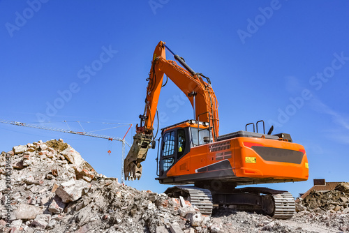 Abrissarbeiten  Bagger auf einer Schutthalde