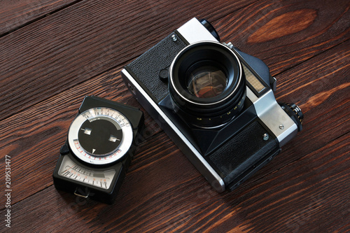 Εκτύπωση καμβά Old retro camera and exposure meter on vintage wooden boards abstract background