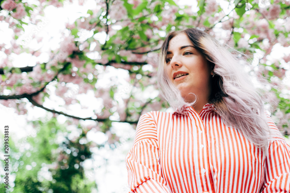 Beautiful Young Woman Enjoying Sunny Day in Park during Cherry Blossom Season Beautiful Young Woman Enjoying Sunny Day in Park during Cherry Blossom Season