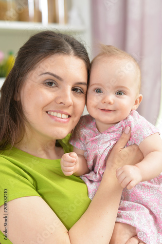 young woman with baby girl at home