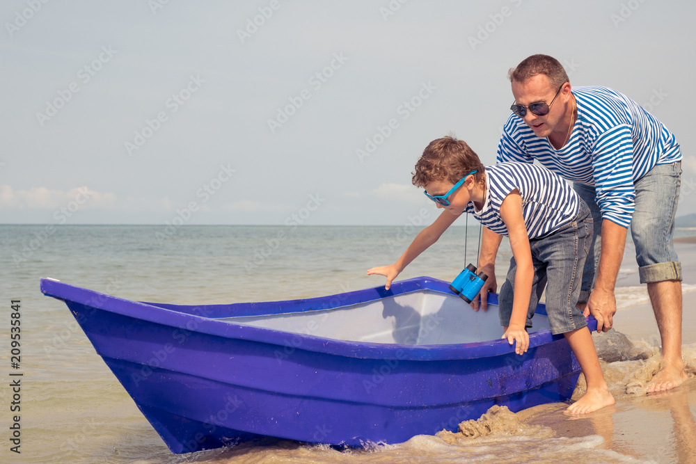 Obraz premium Father and son playing on the beach at the day time.