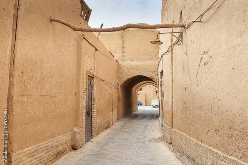 Fototapeta Naklejka Na Ścianę i Meble -  Narrow street with arches of old town in Yazd. Iran