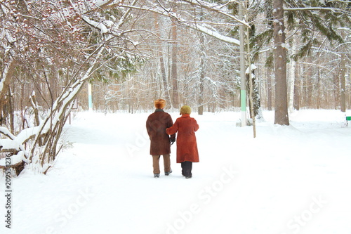 Older people walk in the city park in the winter. Russia, January, 2018.