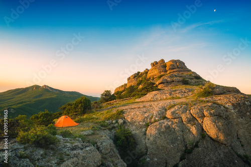 Camping tent on the edge of rocky hill