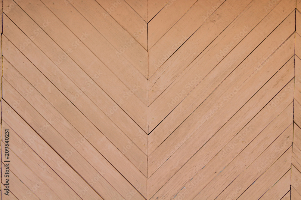 The wall of the house is made of thin boards in the form of a pattern. Close-up. Background. Texture. The wall of the house is made of thin boards in the form of a pattern. Close-up. Background. Texture.
