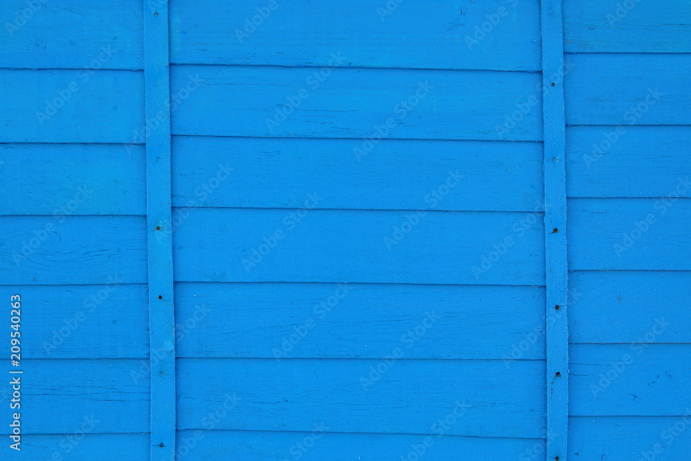The wall of the house is paneled in blue. Close-up. Background. Texture. The wall of the house is paneled in blue. Close-up. Background. Texture.