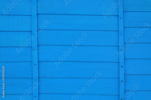 The wall of the house is paneled in blue. Close-up. Background. Texture.