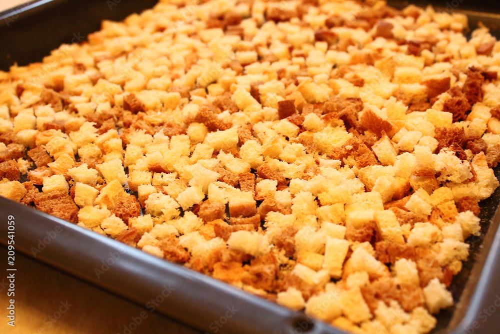 Rusks. Dried bread in the oven, cut into small cubes. Close-up. Background. Rusks. Dried bread in the oven, cut into small cubes. Close-up. Background.