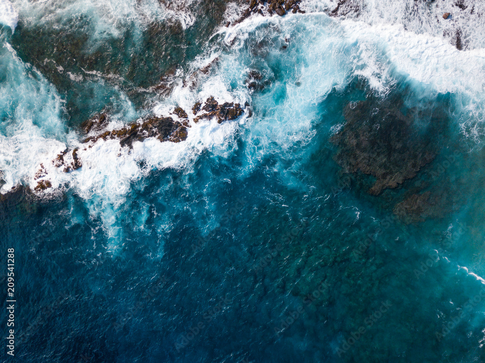 Obraz premium Aerial view of Hawaiian coast with waves splashing against rocks