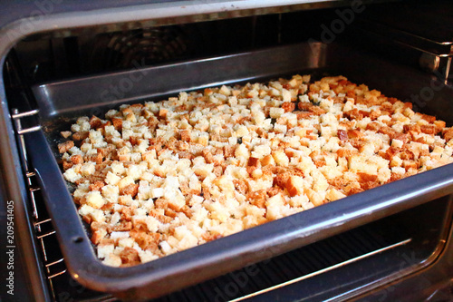 Rusks. Finely diced dried bread on a tray in the oven.