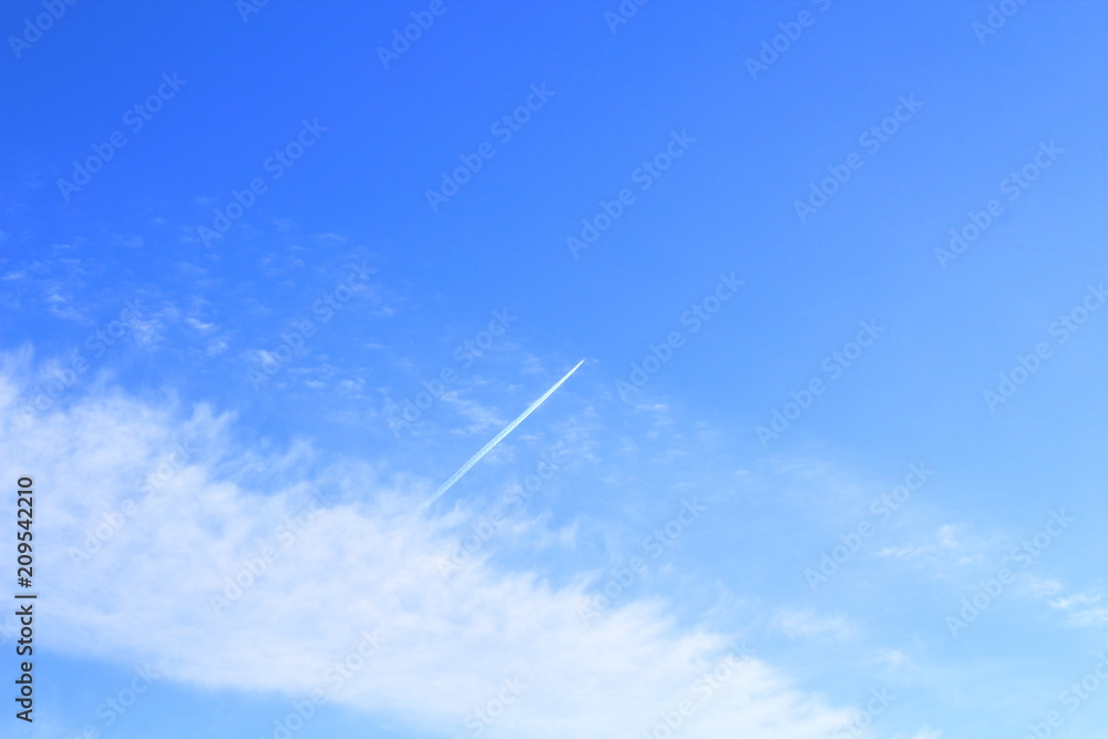 The blue sky and white clouds and the flying high passenger plane. Landscape. Background. Texture. The blue sky and white clouds and the flying high passenger plane. Landscape. Background. Texture.