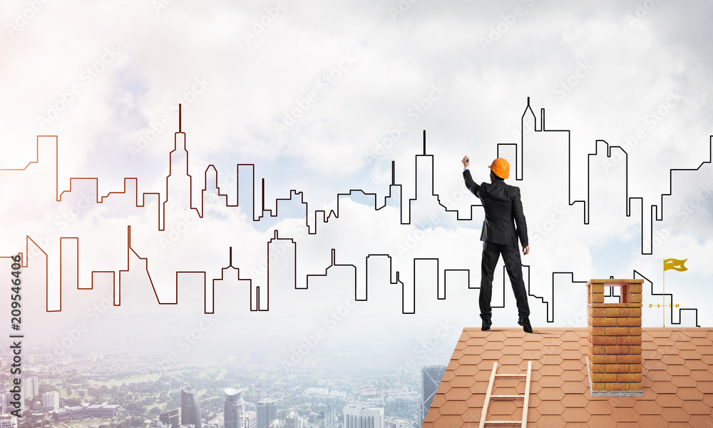Man architect draw silhouette of modern city on blue sky. Mixed media Man architect draw silhouette of modern city on blue sky. Mixed media