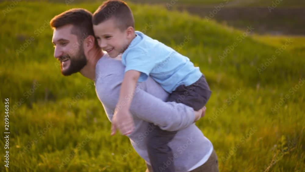 Father and son sitting on his back and playing like airplane Father and son sitting on his back and playing like airplane