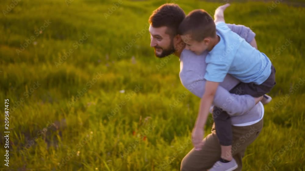 Son cheerfully embracing father sitting on his back Son cheerfully embracing father sitting on his back