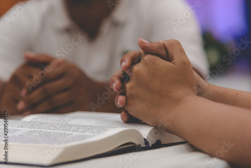 Christian worship praying to the holy scripture. they pray hands Bible in church for the faith and spiritual concept of religion.