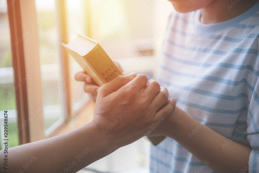Women praying to the holy scripture. Her hand holding hands Bible pray in church for the faith and spiritual concept of religion. Women praying to the holy scripture. Her hand holding hands Bible pray in church for the faith and spiritual concept of religion.