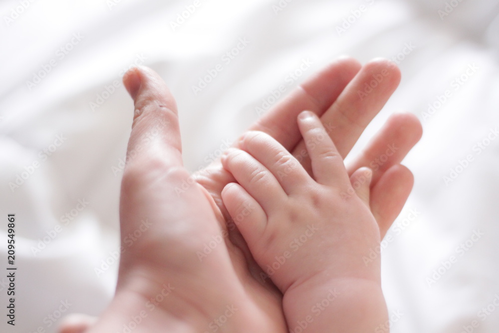 hand of a child on the palm of an adult hand of a child on the palm of an adult