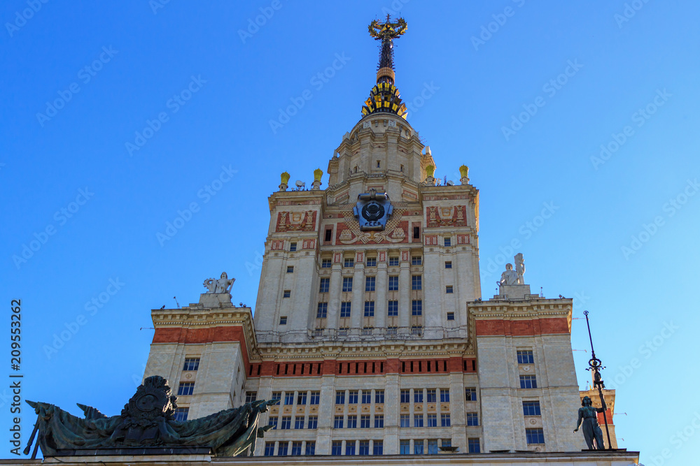 Tower above entrance to main building of Lomonosov Moscow State University (MSU) on a blue sky background