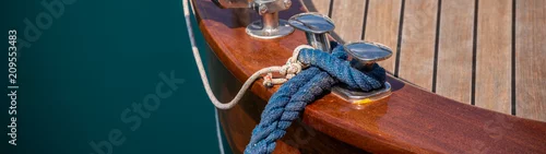 Obraz knaga dokująca z boku łodzi w małej marinie, element wyposażenia jachtowego