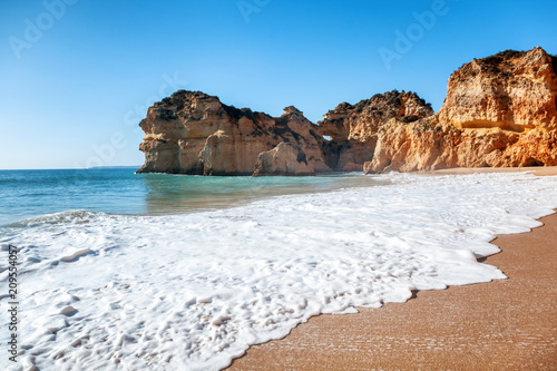 Algarve, Portugal, a stunning sea ocean landscape with yellow rocks and azure water. The beauty of nature and the power of the ocean