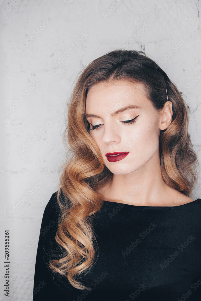 Portrait of a beautiful young girl with hair styling - Hollywood wave in a black dress
