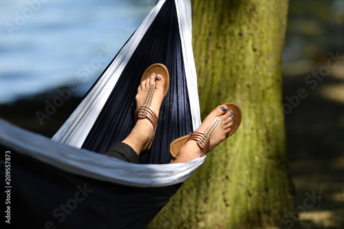 Photography A woman is sleeping in a hammock on a warm and sunny spring day in Germany