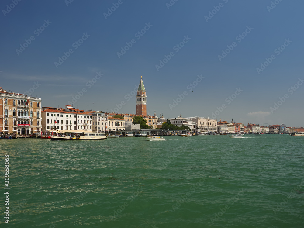 Cityscape of San Marco, Venice, Italy from the lagoon and St Marks Basin with a vaporetto waterbus ferry, Campanile and Doges Palace on the skyline