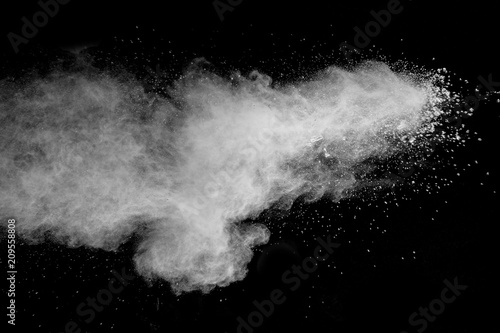 Bizarre forms of white powder explosion cloud against dark background. Launched white particle splash on black background