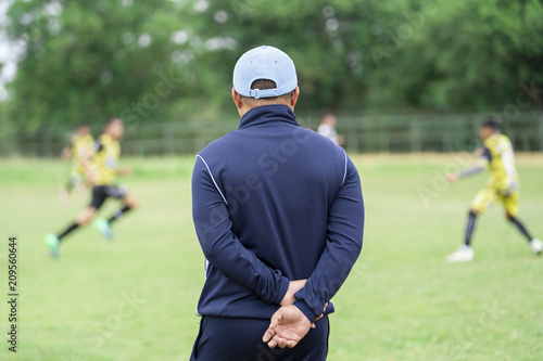 Fototapeta Football or socker coach observing kid football match