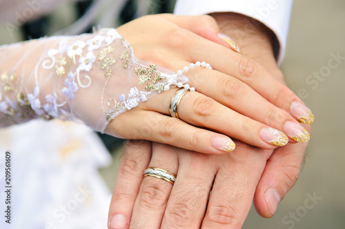 Hands of newlyweds with wedding rings.