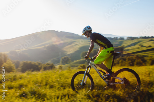 A cyclist on a mountain bike rises uphill. And looks at the scenic landscape.