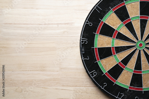 Target dart board on the wooden table background, center point, head to target marketing and business concept photo