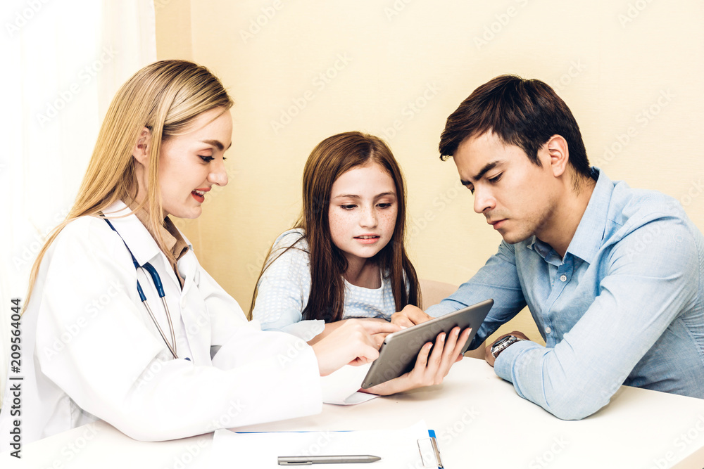 Doctor discussing and consulting with tablet and check up information with little girl and dad in hospital.A little girl has sick.healthcare and medicine Doctor discussing and consulting with tablet and check up information with little girl and dad in hospital.A little girl has sick.healthcare and medicine
