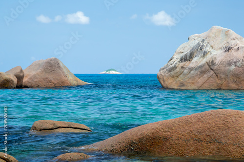 The beach of the Seychelles with blue water and stones