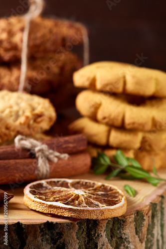 Conceptual composition with assortment of cookies and cinnamon on a wooden barrel, selective focus, close-up © Aleksey