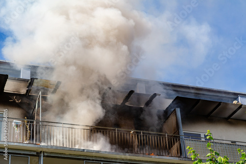 ein Wohnungsbrand in einem Hochhaus, viel Qualm auf dem Balkon