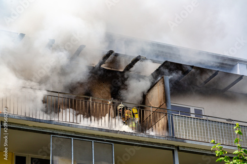 ein Feuerwehrmann versucht ein Wohnungsbrand in einem Hochhaus zu löschen